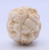 A bone carving formed as various faces. 3.5 cm high.