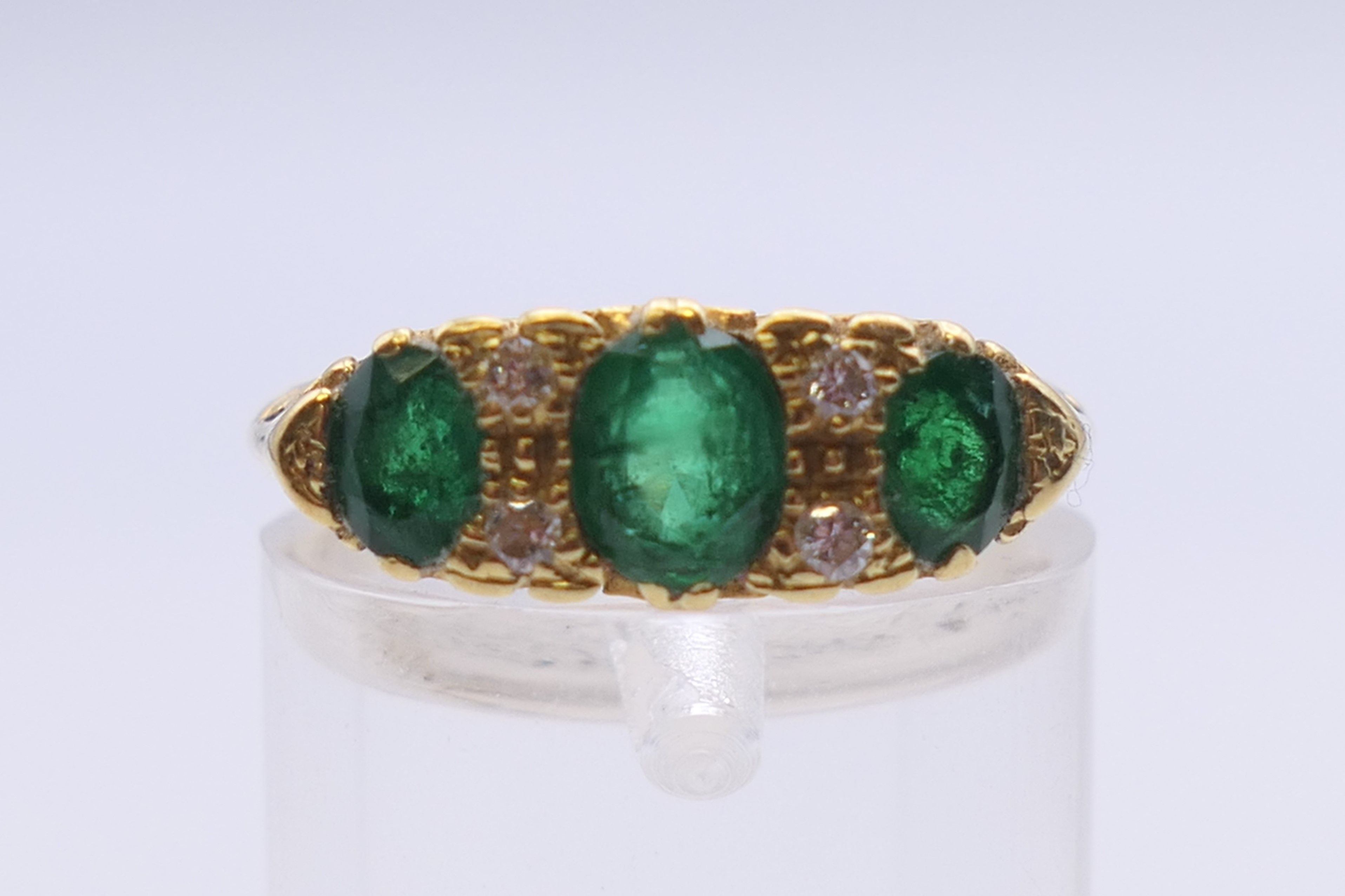 An unmarked gold emerald and diamond ring. Ring size L. 5 grammes total weight. - Image 2 of 5