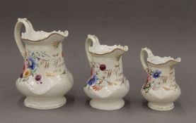 A set of three Victorian porcelain jugs, each inscribed W Onston 1845. The largest 20.5 cm high.