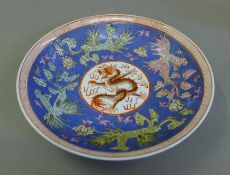 A Chinese blue and red porcelain dragon plate. 22 cm diameter.