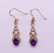 A pair of 9 ct gold and amethyst Celtic rope design earrings. 2.5 cm high. 3.3 grammes total weight.