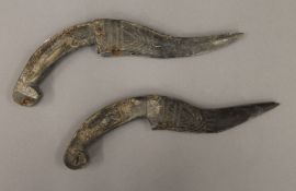 Two Eastern carved wooden daggers. The largest 23 cm long.