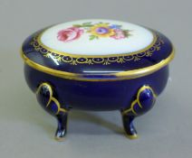 An oval porcelain trinket box. 10 cm long.