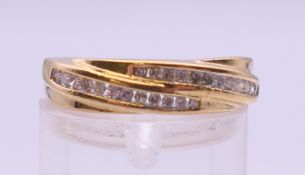 An 18 ct gold diamond cross over ring. Ring size M. 3.6 grammes total weight.