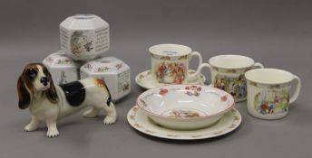 A quantity of Wedgwood, Doulton Bunnykins and Peter Rabbit ceramics, etc. The dog 16 cm long.