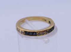 An 18 ct gold diamond and sapphire half eternity ring. Ring size H/I. 2.7 grammes total weight.