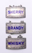 A set of three silver enamel decanter labels. 5 cm wide.