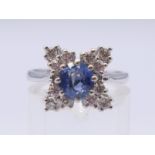 A platinum sapphire and diamond cluster ring. Ring size N.