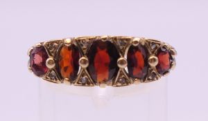 A 9 ct gold garnet and diamond ring. Ring size P. 5.2 grammes total weight.
