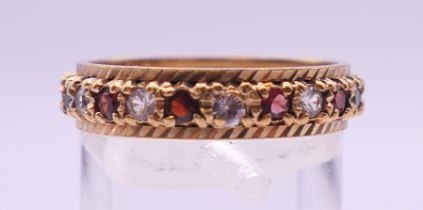 A 9 ct gold gem set full eternity ring. Ring size Q/R. 3.6 grammes total weight.