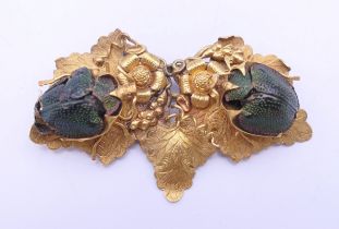 A Victorian gilt brooch set with two scarab beetles. 5 cm wide.