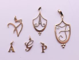 Six 9 ct gold alphabet pendants. The largest 4 cm high. 7.6 grammes.