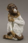 A 19th century porcelain model of a monkey. 19 cm high.