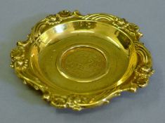 A silver gilt coin dish. 10 cm diameter.