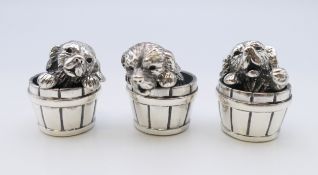 Three Saturno 925 silver puppies in barrels. Each approximately 2.5 cm high.