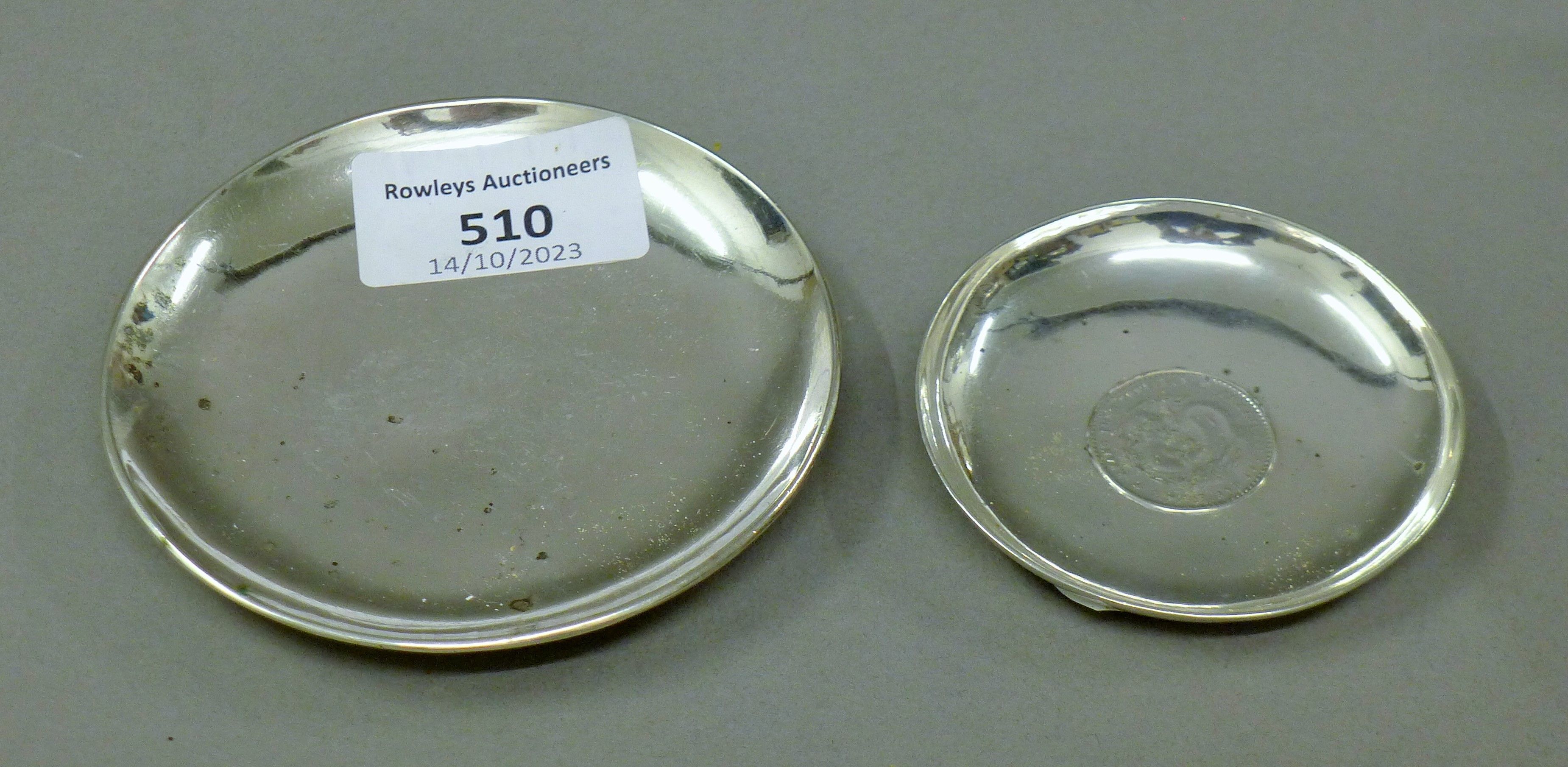 Two small Chinese silver dishes, one set with a coin. The largest 9 cm diameter. 88.