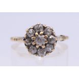 An unmarked gold and diamond cluster ring. The head approximately 9 mm diameter.