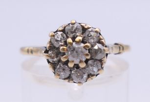 An unmarked gold and diamond cluster ring. The head approximately 9 mm diameter.