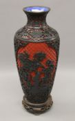 A cinnabar lacquer vase on wooden stand. 34 cm high.