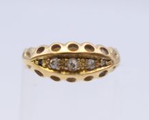 An 18 ct gold three stone diamond ring. Ring size G.