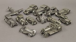 A collection of metal models of vintage cars and a spitfire. The latter 13.5 cm wide.