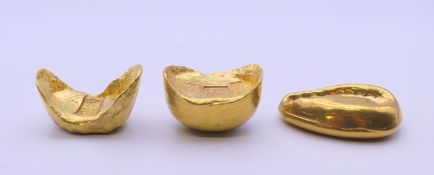 Three Chinese gold coloured scroll weights. The largest 5 cm long.