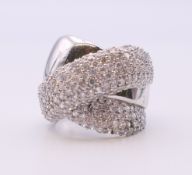 A silver cubic zirconia cross over ring. Ring size P.