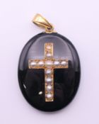 A 19th century enamel and seed pearl locket with 15 ct gold suspension loop. 5 cm high.