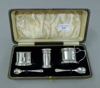 A cased three piece silver cruet set, spoons associated and one plated. 56.