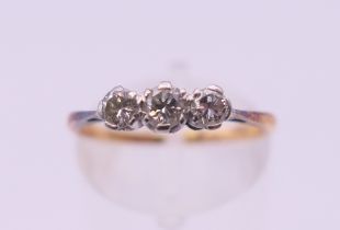 An 18 ct gold and platinum three stone diamond ring. Ring size M.