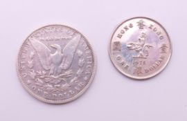 A silver 1901 dollar coin and a Hong Kong dollar coin.