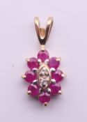 A 9 ct gold diamond and ruby pendant. 1.5 cm high.