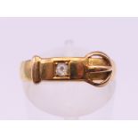 An 18 ct gold diamond set buckle ring. Ring size M. 2.1 grammes total weight.