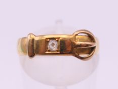 An 18 ct gold diamond set buckle ring. Ring size M. 2.1 grammes total weight.