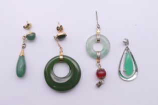 Four jade pendants and earrings. The largest 5 cm high.