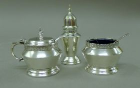 A three piece silver cruet set, spoons associated and one plated. 163 grammes. The pepper 8.5 cm.
