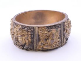 A gilt metal bracelet decorated with various deities. Internal width approximately 5.5 cm.