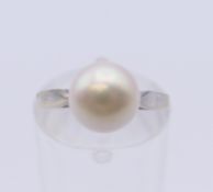 An 18 ct white gold solitaire pearl ring. Ring size I/J. 3.1 grammes total weight.