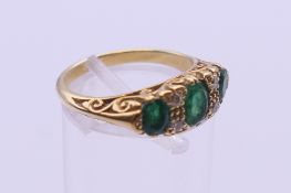 An unmarked gold emerald and diamond ring. Ring size L. 5 grammes total weight.