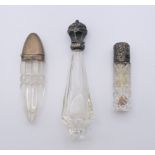 Three silver topped scent bottles. The largest 12 cm high.