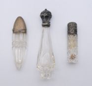 Three silver topped scent bottles. The largest 12 cm high.