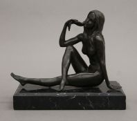 A bronze figure of a female nude on a marble plinth base. 21 cm long overall.
