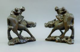 A pair of Chinese hardwood buffalo, each carved with children on their back. 21 cm high.