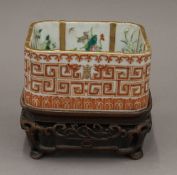 A 19th century Chinese square section bowl on carved wooden stand. 12.5 cm high overall.