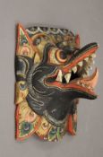 An Eastern painted wooden wall mask. 17.5 cm wide.