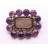 A 19th century unmarked gold amethyst and hair plait mourning brooch. 2.5 cm wide.