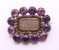 A 19th century unmarked gold amethyst and hair plait mourning brooch. 2.5 cm wide.