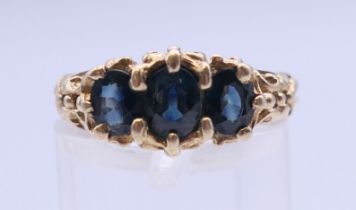 A 9 ct gold three stone sapphire ring. Ring size N/O. 3.2 grammes total weight.