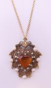 A 9 ct gold citrine and seed pearl pendant on a 9 ct gold chain.