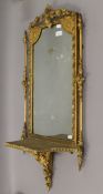 A Victorian gilt framed mirror with integral bracket. 95 cm high.